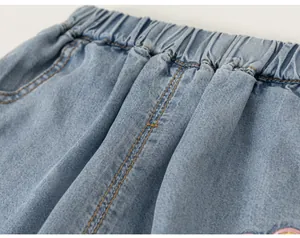 Detalle macro de la cintura elástica y las costuras en pantalones vaqueros de niña