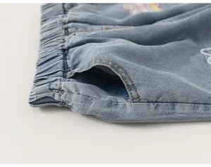 Detalle en primer plano de la cintura elástica y el bolsillo de un vaquero ancho azul de niña