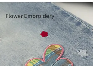 Primer plano de bordado de flores y parche de cuadros en pantalones vaqueros azules