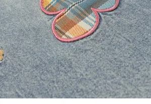 Primer plano de un parche bordado de flores a cuadros en unos pantalones vaqueros
