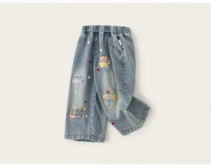 Detalle de pantalones vaqueros anchos para niños con parches de flores y bordados