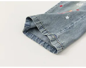 Primer plano del dobladillo de unos vaqueros anchos para niña con bordados