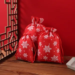 Red Christmas drawstring burlap bags with white snowflake patterns in various sizes.