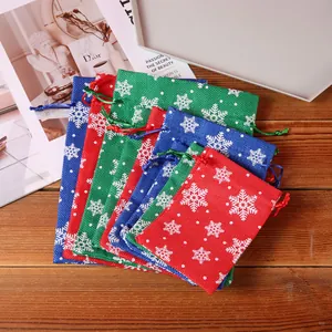 Set of colorful Christmas burlap drawstring gift bags with white snowflake patterns.