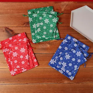 Snowflake Christmas drawstring gift bags in red, green, and blue imitation linen