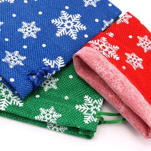 Macro detail of Christmas burlap gift bags with snowflake pattern and drawstring.