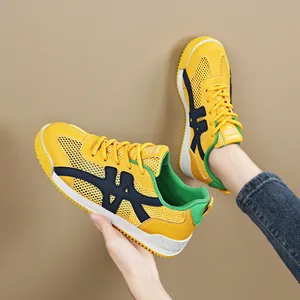 Felgele ademende mesh dames sneakers met dikke witte zolen en opvallende groene accenten