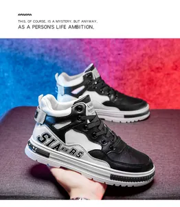 Detailed side view of black and white mid-top lace-up sneakers with stylish lettering