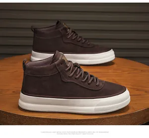 Detailed side view of brown suede mid-top work boots with thick white rubber soles