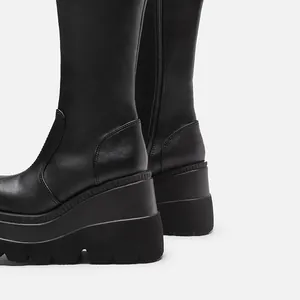 Detailweergave van zwarte platformlaarzen met een dikke zool en gothische stijl.
