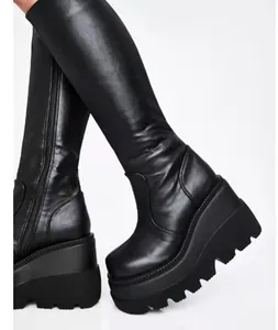 Detailweergave van zwarte platform wedge boots met dikke zool en zijrits