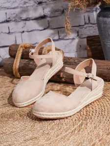 Vista detallada de las sandalias de cuña tipo alpargata de ante beige con plataforma de cáñamo.
