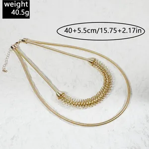 Detailed view of a gold double-layered metal collar necklace with spring coil decorative element
