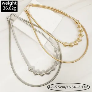 Macro view of gold and silver metallic snake chain chokers with ridged geometric details.