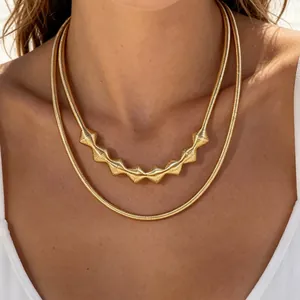 Close-up of golden geometric choker set with textured beads and sleek snake chain.