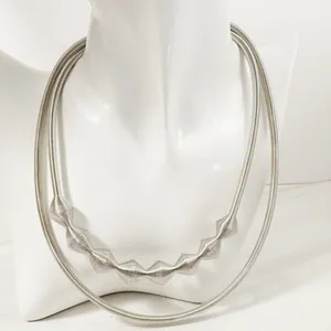 Detailed view of fashionable silver geometric metal choker necklace on white mannequin bust