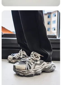 Dettaglio di sneakers chunky grigie con lacci spessi e suole effetto invecchiato