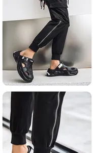 Close-up detail of black men's closed-toe sandals with thick soles and FXED strap