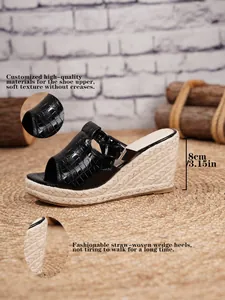 Detailed view of black croc-embossed sandal featuring 8cm straw-woven wedge heel