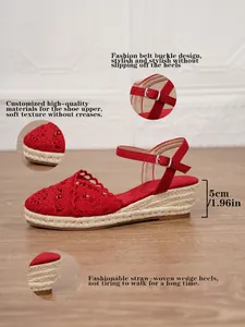 Detalles de sandalias de cuña rojas con tacón de 5 cm y textura de paja tejida.