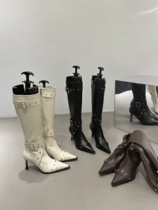 Various colors of French retro tall boots with studs and buckled straps in a studio setting