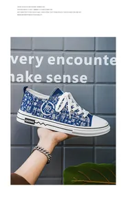 Vista dettagliata delle scarpe di tela blu con stampa di caratteri cinesi bianchi.