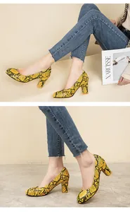 Detailed views of yellow snakeskin pattern pumps with chunky heels and round toes
