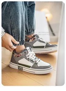 Dettaglio ravvicinato di sneaker casual in pelle foderata da uomo in grigio e bianco.
