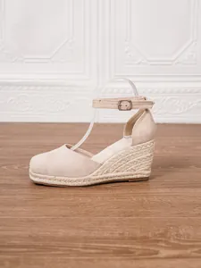 Vista lateral de sandalias de cuña beige para mujer con tacón de esparto trenzado y hebilla