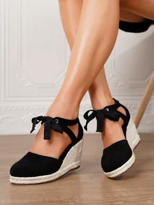 Elegantes sandalias de esparto con cuña en ante negro para mujer, vista puesta real