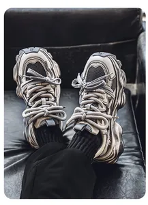 Dettaglio ravvicinato delle sneakers chunky grigie effetto invecchiato con lacci spessi in mesh