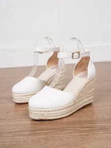 Nahaufnahme weißer Espadrille-Keilsandalen mit geflochtenem Seil-Plateauabsatz