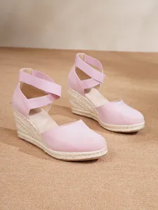 Elegantes sandalias de cuña de esparto rosa con punta cerrada y tiras elásticas al tobillo