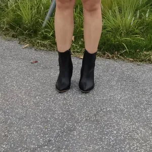 Détail de bottines noires élégantes à bout pointu et talon aiguille avec fermeture éclair