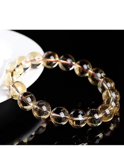 Close-up of a high-quality natural yellow citrine crystal bead bracelet on a reflective surface