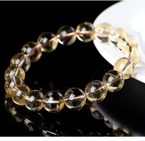 Macro detail of natural translucent yellow citrine bead bracelet on black surface