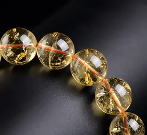 Macro detail of natural yellow citrine quartz beads showing unique internal ice cracks