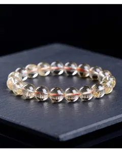 Macro detail of natural yellow citrine round bead bracelet with red elastic cord