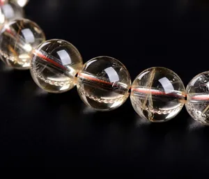 Close-up macro detail of natural yellow rutilated quartz beads showing clear internal inclusions