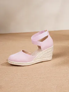 Vista lateral de sandalias de cuña rosas cerradas con suela de yute trenzado y correa