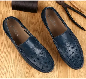 Vista superior de mocasines de cuero azul con textura perforada y costuras a mano.