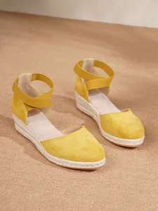 Vista detallada de sandalias de cuña tipo alpargata de ante amarillo con correas