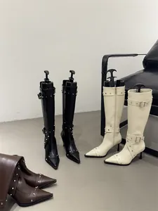 Group shot of French retro studded high-heeled long boots in black, white and brown.