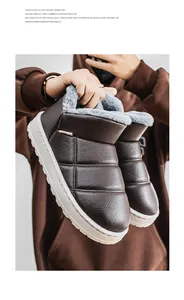 Close-up view of brown fur-lined waterproof slip-on winter boots for men held by person