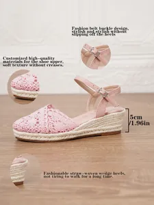 Detalle de sandalias de cuña de ganchillo rosa con correa y tacón de paja de 5 cm