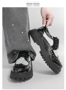 Close-up detail of black and white patent leather men's platform shoes with gold studs