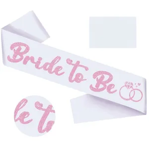 Detail of pink glitter 'Bride to Be' lettering on elegant white satin party sash