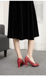 Side view of elegant red snakeskin patterned pumps with chunky heels and round toes