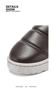Close-up detail of textured brown leather on winter slip-on padded men's shoes.