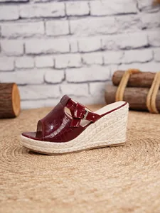 Close-up of burgundy crocodile pattern wedge sandal with espadrille platform heel.